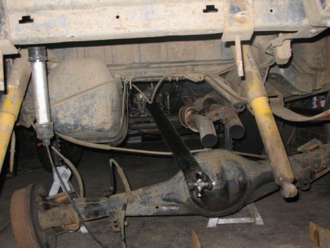 1981 Ford Bronco - The rear axle assembly and suspension components are visible, with the fuel tank and exhaust system also in view.