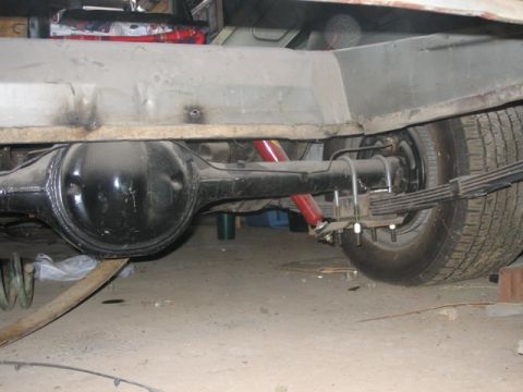 1981 Ford Bronco - Close-up view of a vehicle's rear axle, shock absorbers, and leaf spring suspension system.