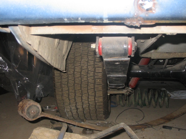 Close-up of rear suspension parts, including a leaf spring and shock absorber, on a vehicle