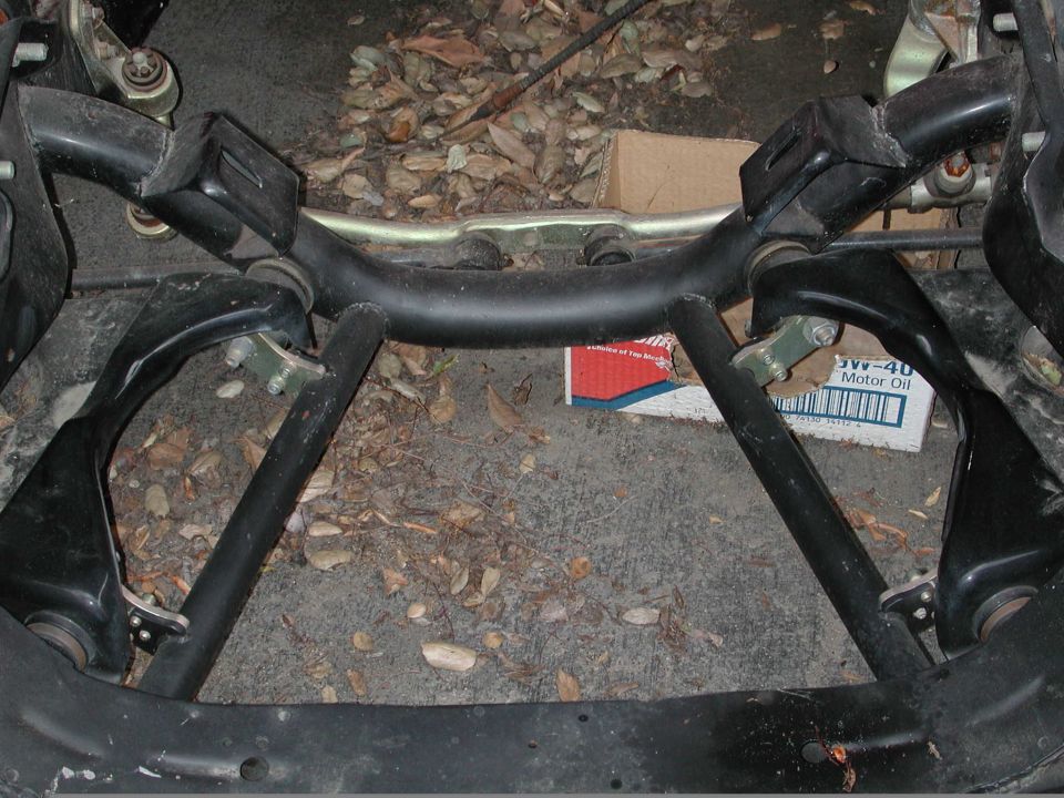 Car's front suspension parts, possibly from a Ford. Box of 5W-40 motor oil visible