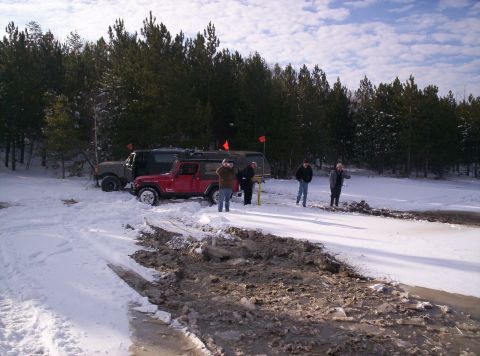 1996 Ford Bronco - Off-road vehicles navigate challenging terrain in a snowy and muddy environment.