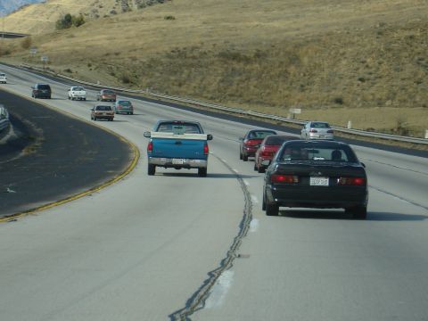 1995 Ford Taurus - Multiple vehicles travel on a multi-lane highway under a clear sky.