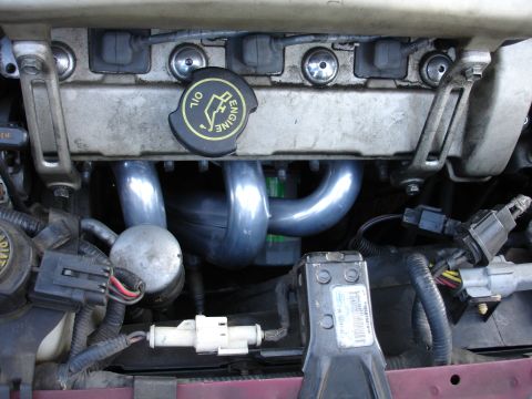 1995 Ford Taurus - Close-up of an engine bay, focusing on the exhaust manifold and associated components.