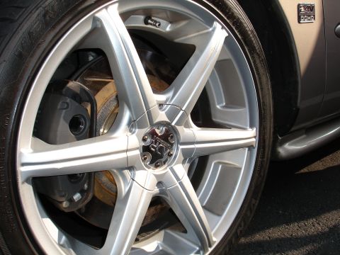 1995 Ford Taurus - A close-up shot focuses on a custom alloy wheel and the fender of a vehicle, revealing a '24V DOHC' badge.