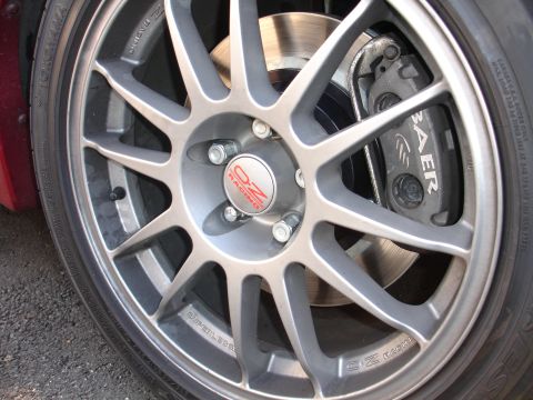 1995 Ford Taurus - A close-up view of a custom wheel an OZ Racing center cap and a Baer brake caliper, indicating performance modifications.