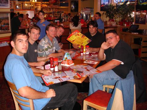 1995 Ford Taurus - Friends gather around a table at a restaurant, looking over menus and talking.