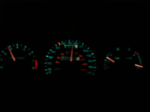 1995 Ford Taurus - The illuminated dashboard gauges show the speedometer, tachometer, fuel, and temperature readings in the dark.