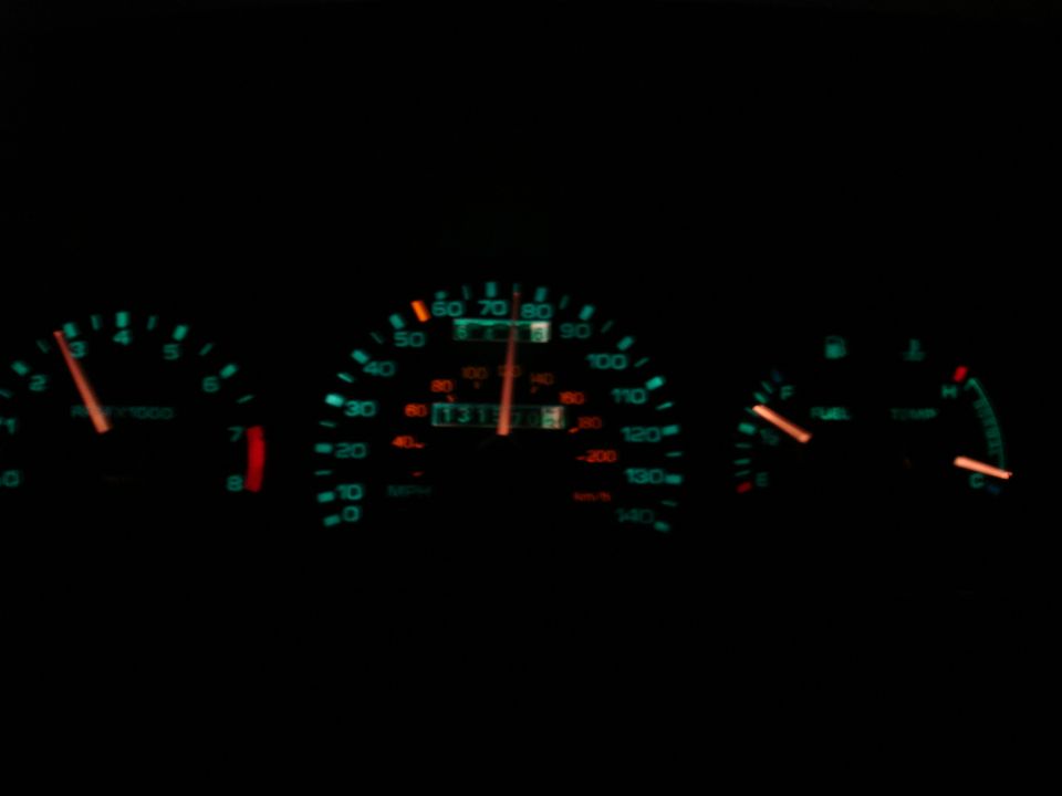 Dashboard gauges with illuminated speedometer, tachometer, fuel, and temperature gauges