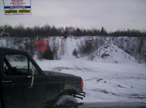 1996 Ford Bronco - A vehicle navigates a snowy landscape with a dirt track leading up a hill.