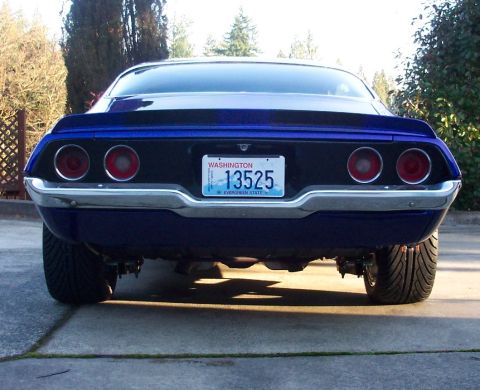 1970 Chevrolet Camaro - The rear of a blue muscle car is shown, quad taillights and a chrome bumper.