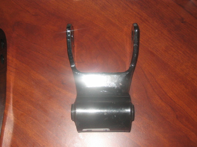 black metal leaf spring shackle with bushings on a wood surface