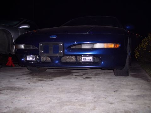 1995 Ford Probe - The front of a blue Ford Probe is shown at night, with its headlights and fog lights illuminated.