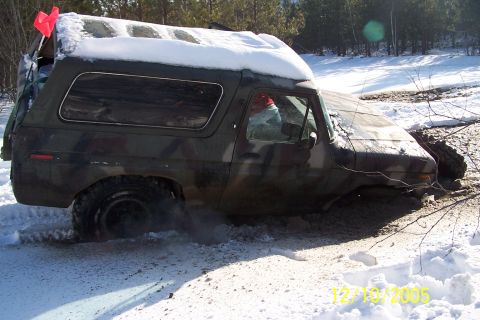1979 Ford Bronco - Ford Bronco stuck in snow and mud, with a red flag on its roof.