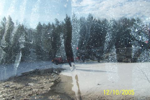 1979 Ford Bronco - View through a snow-covered windshield shows a red SUV and other vehicles in a winter landscape.
