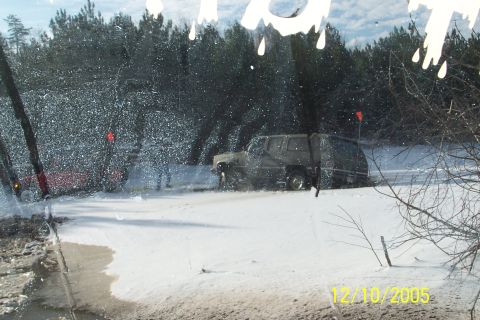 1979 Ford Bronco - An off-road vehicle navigates a snowy terrain, with another vehicle in the background.