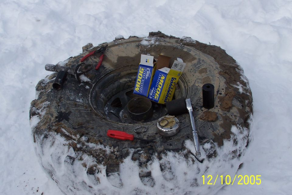 Tire with MOOG parts and tools in snow