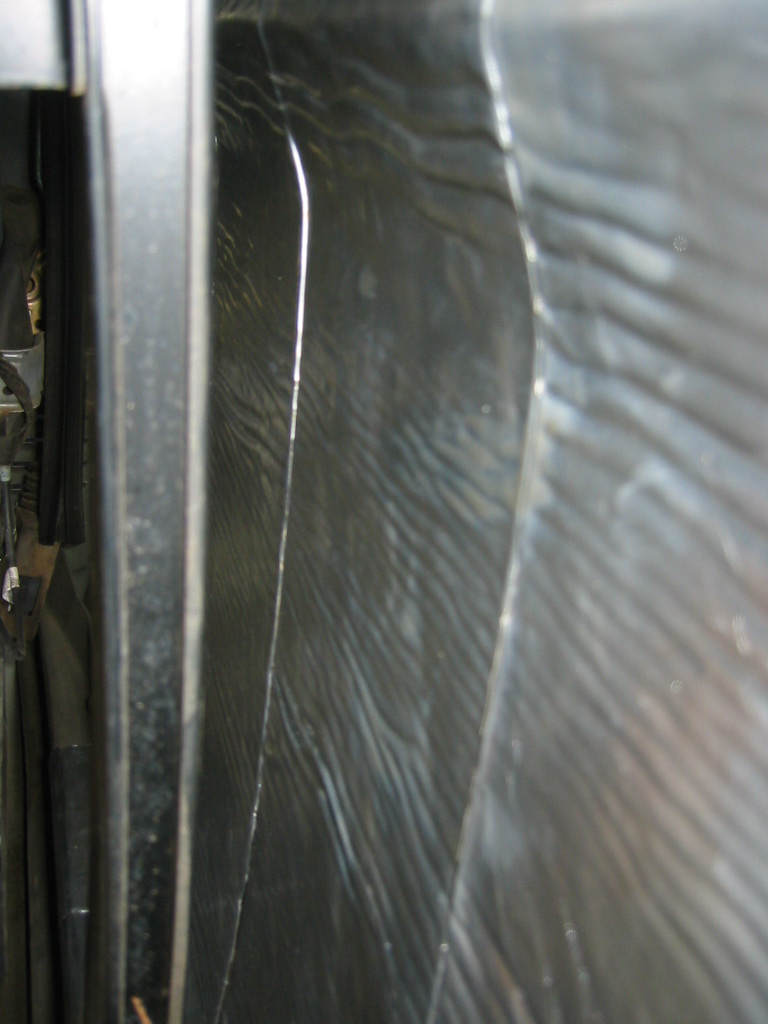 Close-up of black textured sound deadening mat on a vehicle door panel