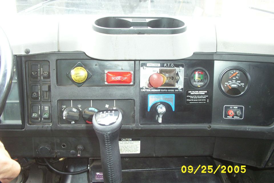 Truck cab dashboard with shifter, gauges, PTO control and labeled switches