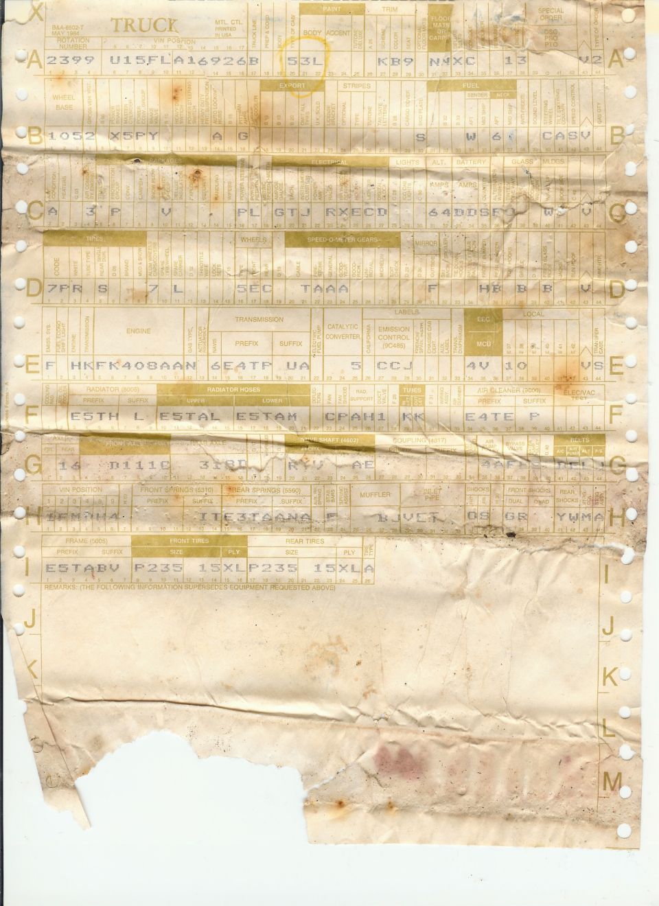 Water-stained Ford truck build sheet with coded rows A through M, partly torn at the bottom