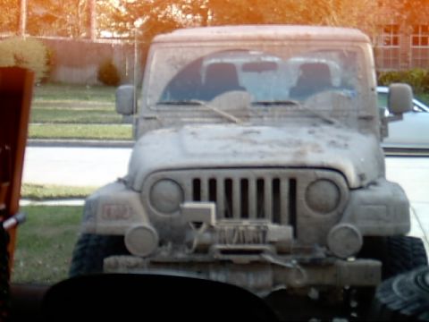 2004 Jeep Wrangler - Mud-covered 2004 Jeep Wrangler with a winch mounted on the front bumper.