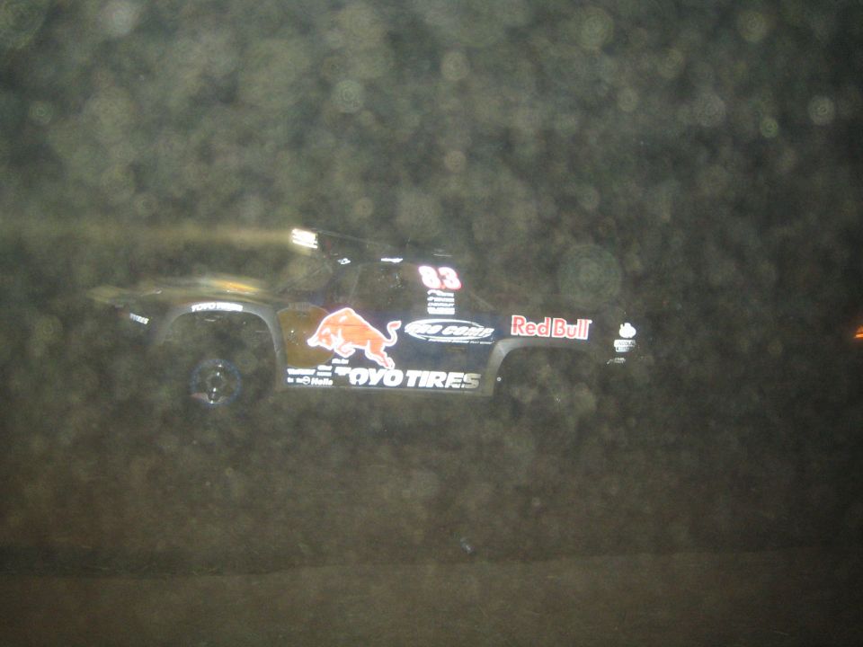 Dark off-road race truck with Red Bull, Toyo Tires and bull logo at night