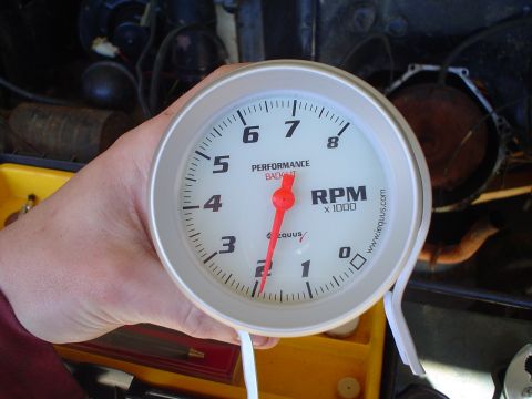 1984 Ford Bronco - A close-up of a tachometer gauge, showing RPM x 1000, held in a person's hand.