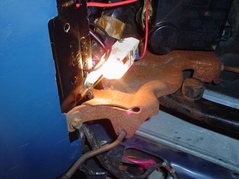 1984 Ford Bronco - A close-up view of electrical components and a rusty bracket within a vehicle's interior.