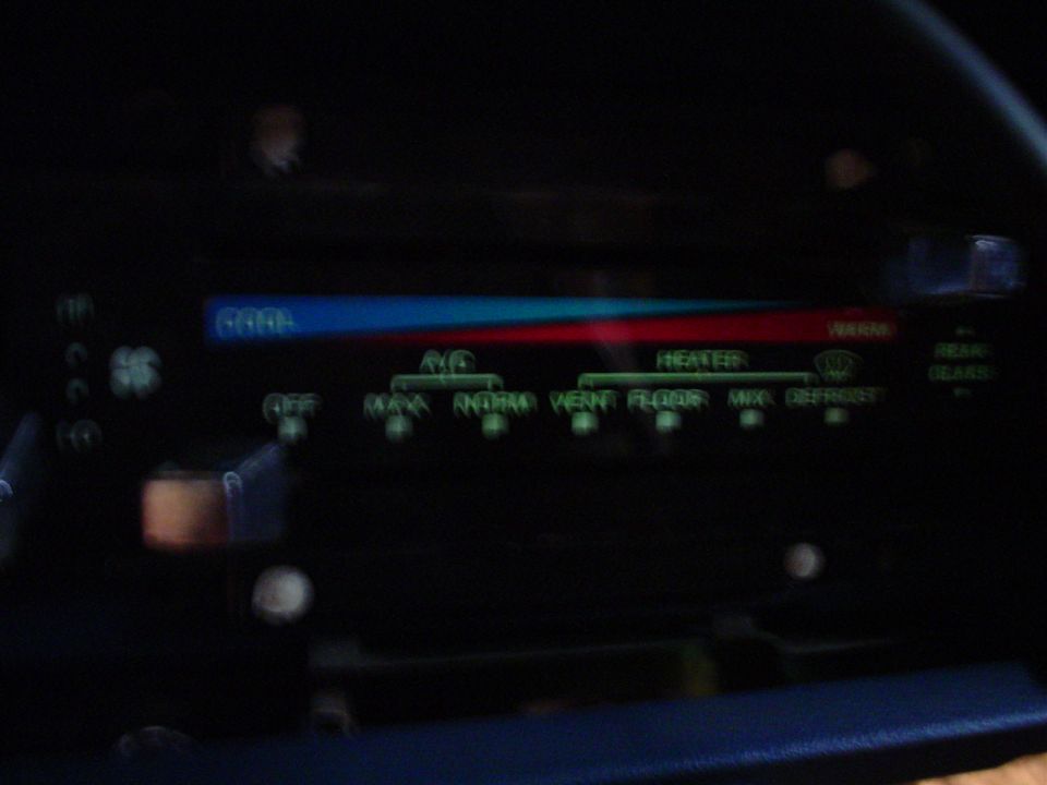 Climate control panel with blue/red temperature slider and green text labels for AC, Heater, Vent, Floor, Defrost