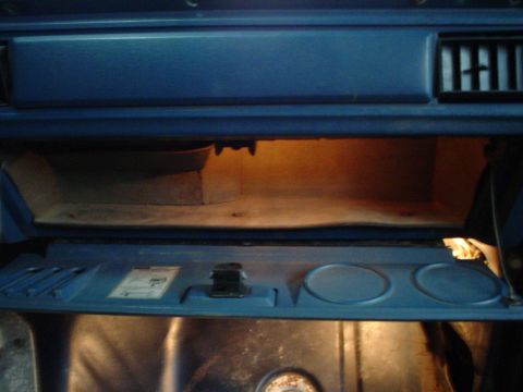 1984 Ford Bronco - Interior view of a 1984 Ford Bronco's open glove box with the interior light on.