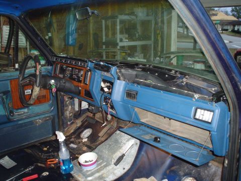 1984 Ford Bronco - The dashboard of a vehicle is disassembled, revealing exposed wiring and internal components during a rebuild process.