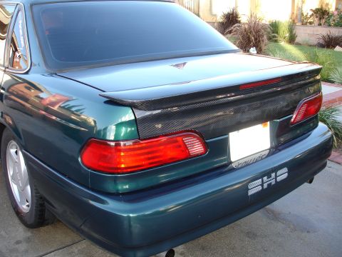 1993 Ford Taurus - Rear view of a green sedan with a carbon fiber spoiler and SHO badging.