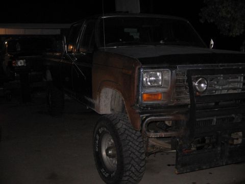 1986 Ford F-350 - Front 3/4 view of an older Ford pickup truck at night, with another vehicle behind it.