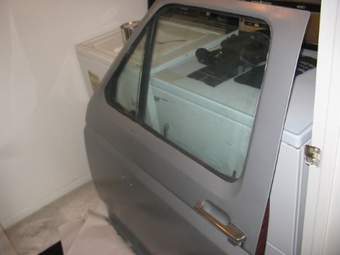 1991 Ford Bronco - A single car door is shown, detached from a vehicle, against a backdrop of appliances.