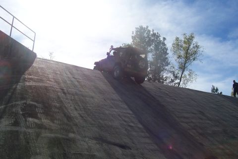 1987 Ford Bronco - A red 1987 Ford Bronco navigates a challenging concrete slope, its off-road capabilities.