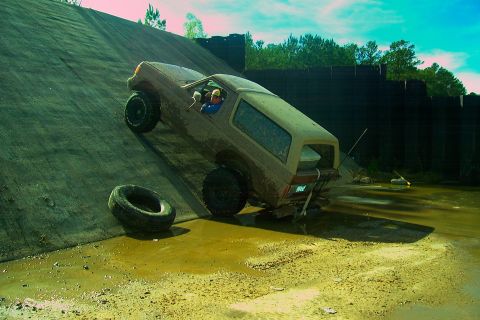 1987 Ford Bronco - This 1987 Ford Bronco is attempting to ascend a challenging muddy obstacle.