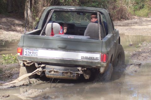 1987 Ford Bronco - This 1987 Chevrolet K5 Blazer is stuck in the mud, showing its rear end and the 'CHEVROLET' badging.