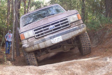 1987 Ford Bronco - 1987 Ford Bronco navigating rough terrain during an off-road excursion.