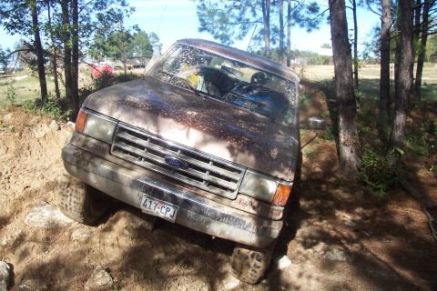 1987 Ford Bronco - 1987 Ford Bronco tackling an off-road trail, showing its capability on challenging ground.