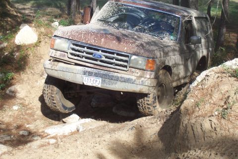 1987 Ford Bronco - This 1987 Ford Bronco is shown off-roading through a muddy, uneven terrain.