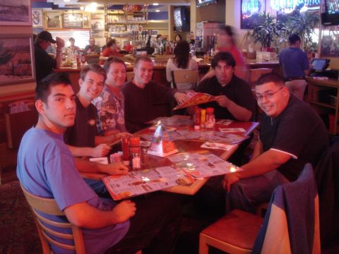 1991 Ford Taurus - Several men are seated around tables in a restaurant, looking at menus.
