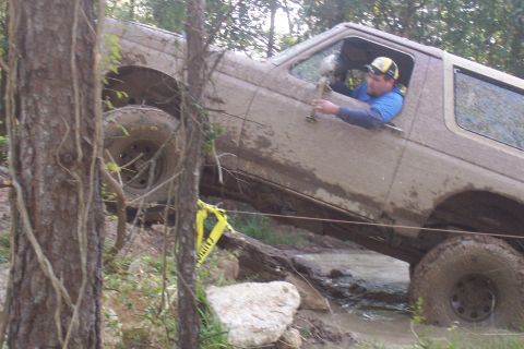 1987 Ford Bronco - Muddy 1987 Ford Bronco tackling a challenging off-road course.