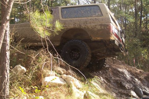 1987 Ford Bronco - This 1987 Ford Bronco navigates a challenging off-road course covered in mud and rocks.