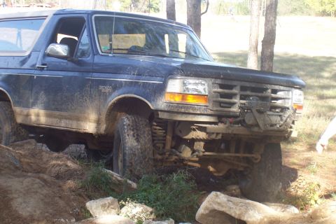 1987 Ford Bronco - Ford Bronco is shown off-roading over rocks and dirt.