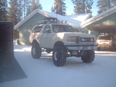 1989 Ford Bronco - Modified 1989 Ford Bronco in a snowy setting, a roof rack and oversized tires.