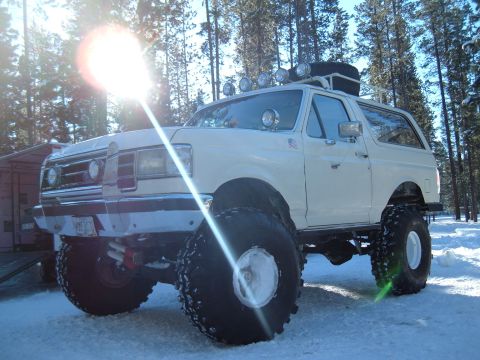 1989 Ford Bronco - This modified SUV is equipped with oversized tires and a roof rack, ready for snowy terrain.