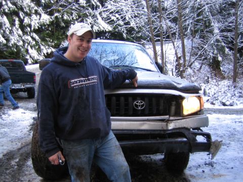 1990 Ford Bronco - A man poses next to a Toyota Tacoma in a snowy, wooded area, with another truck visible in the background.