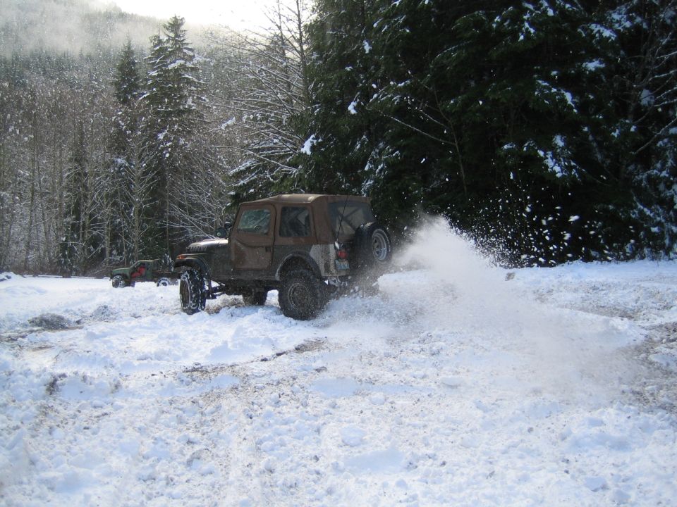 Jeep Wrangler kicking up snow, another Jeep in background