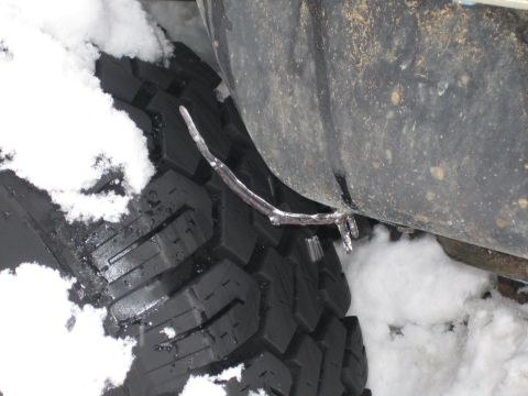 1990 Ford Bronco - Icicles hang from the fender above a tire covered in snow, suggesting cold weather conditions.