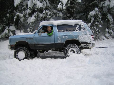 1990 Ford Bronco - Dodge Ramcharger navigating deep snow off-road.