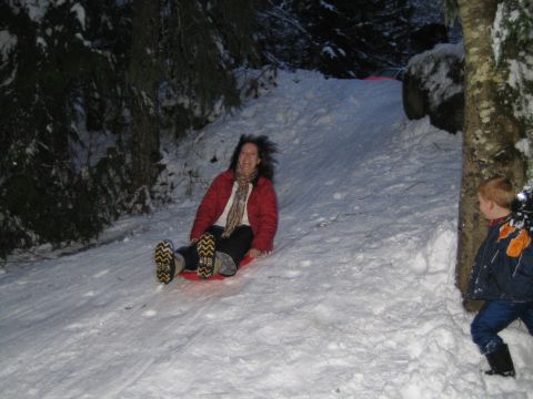 1990 Ford Bronco - Two people enjoy a winter day sledding down a snowy slope.